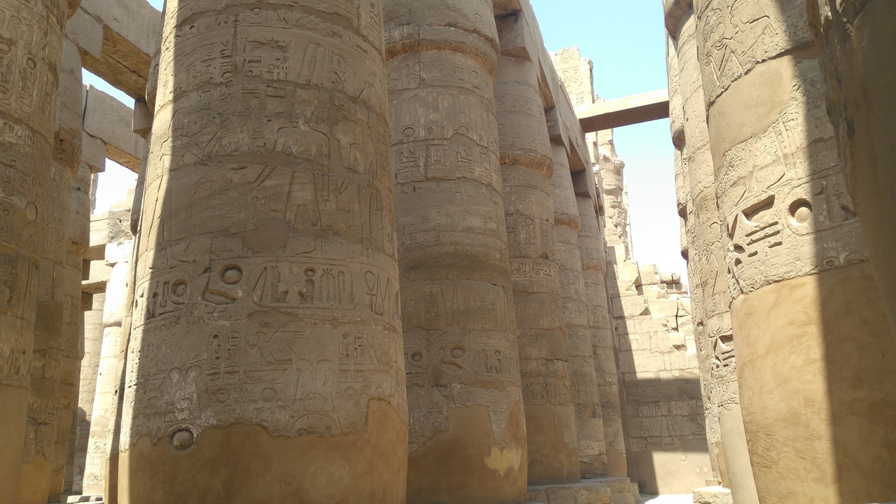 Anciennes colonnes de pierre avec hiéroglyphes, faisant partie d'une structure de temple.