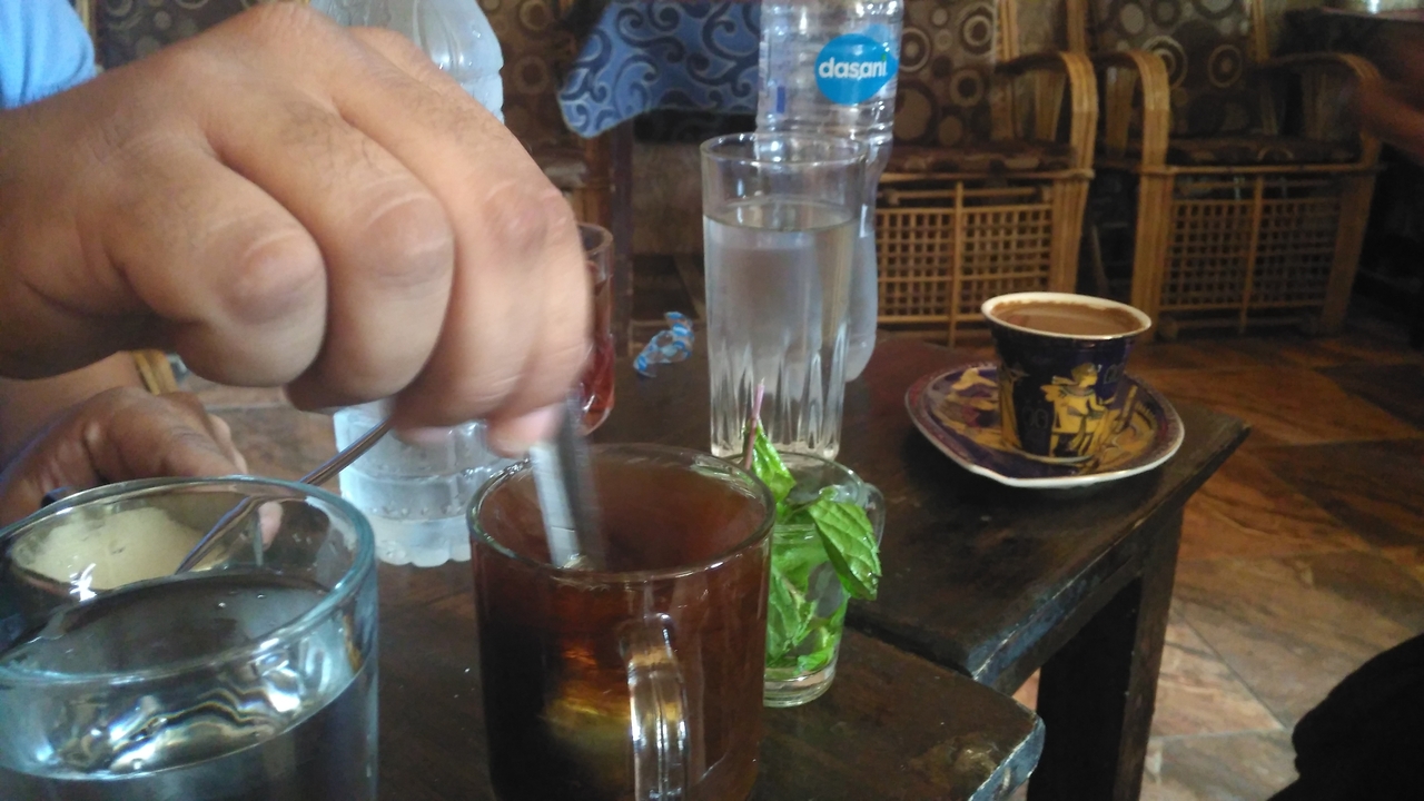 Gros plan d'une personne remuant une boisson dans un cadre social.