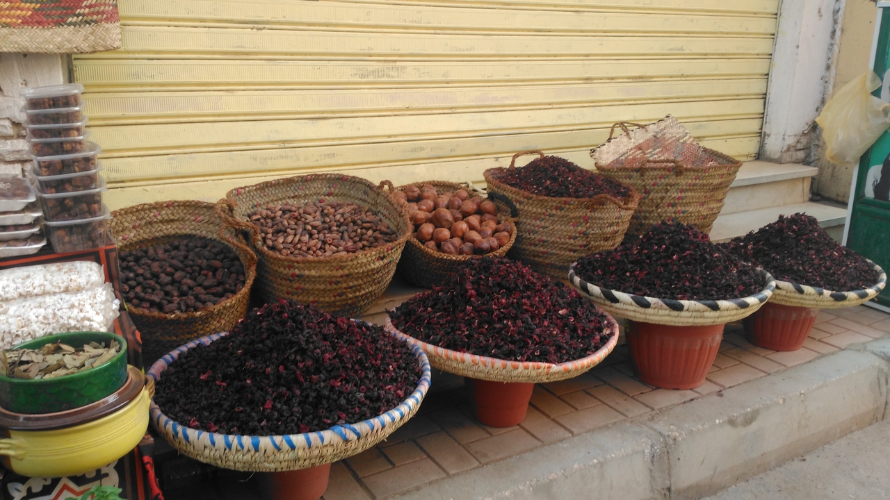 Diverses épices exposées dans des paniers au marché.