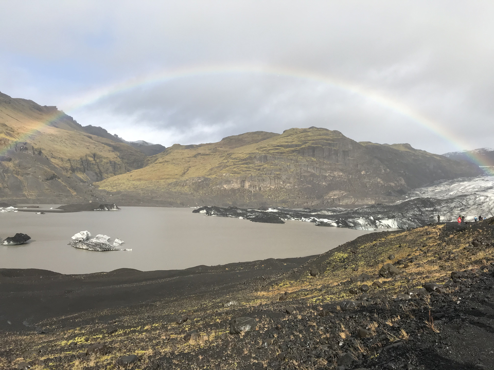 Scenic view of a lake with mountains and a rainbow.