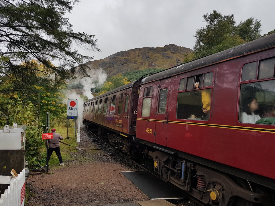 Train filant sur des rails à travers des collines boisées.