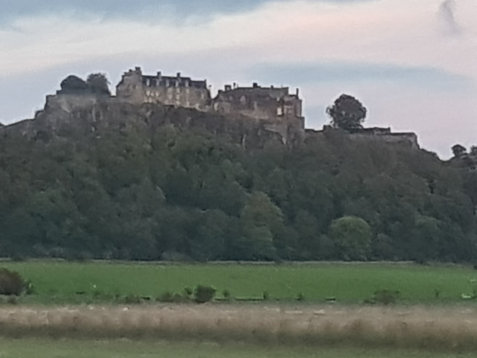 Vue lointaine d'un château sur une colline.