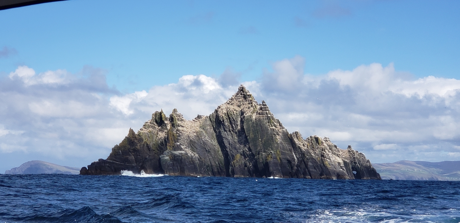 Rocky island with waves crashing around it.