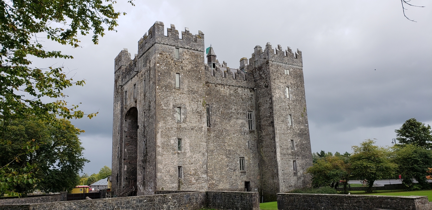 Historic stone castle with lush greenery surrounding.