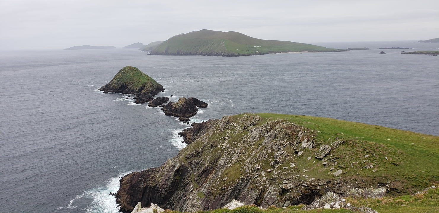 Rocky coastal landscape with islands and rough seas.