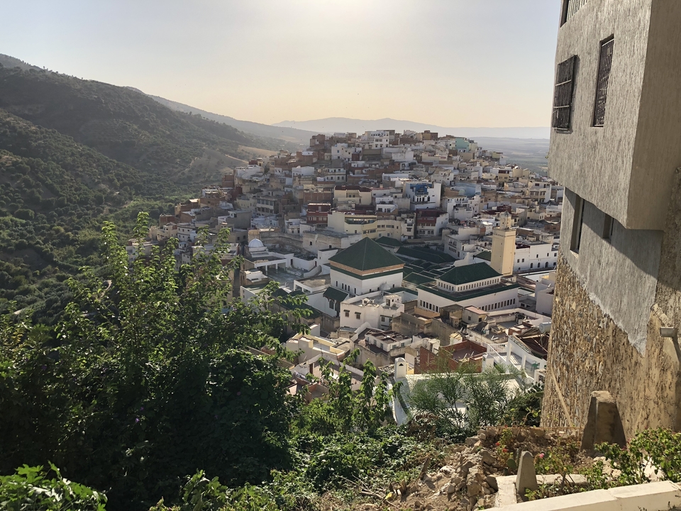 Vue panoramique d'une ville entourée de collines.