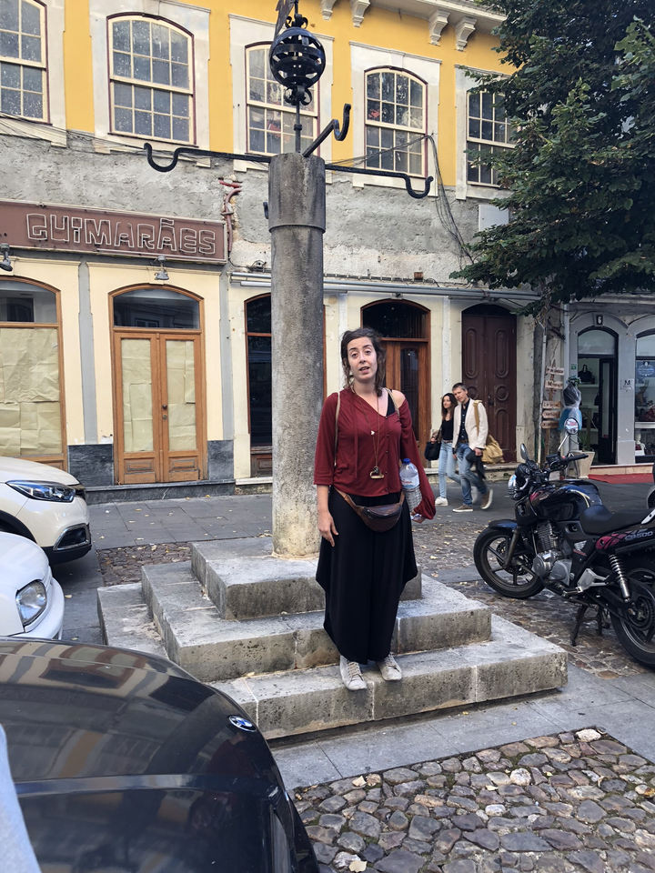 Femme posant près d'une colonne dans une rue de la ville.