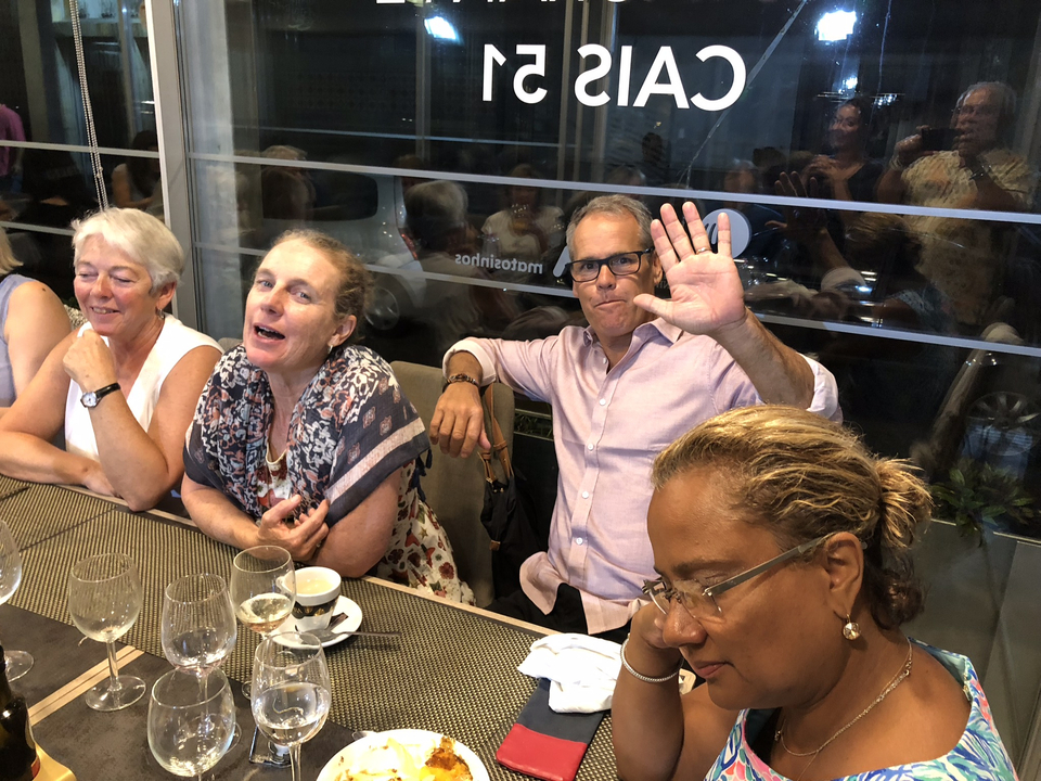Des gens posant à une table de restaurant avec des verres vides.