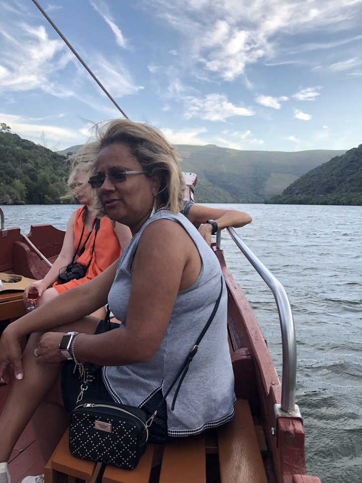 Femmes assises sur un bateau avec vue sur la vallée.