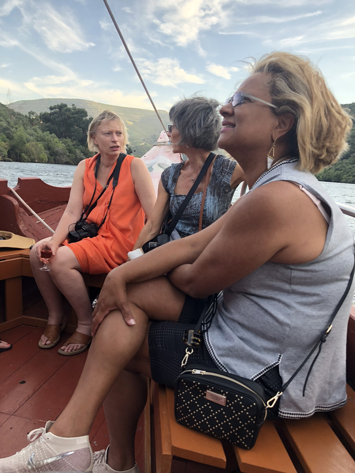 Trois femmes assises sur un bateau avec des appareils photo.