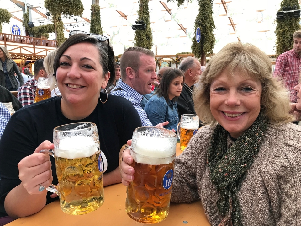 Deux femmes savourant de grandes chopes de bière lors d'un festival de la bière.