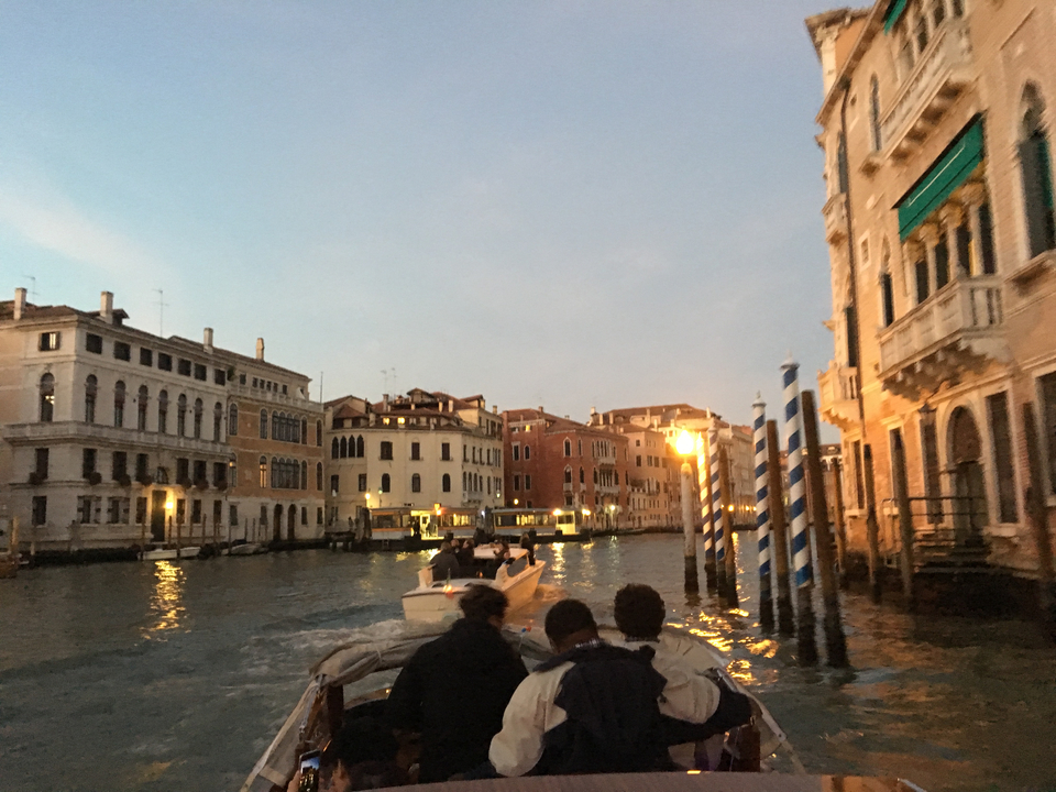 Bateau sur un canal avec des bâtiments historiques dans la lumière du soir.