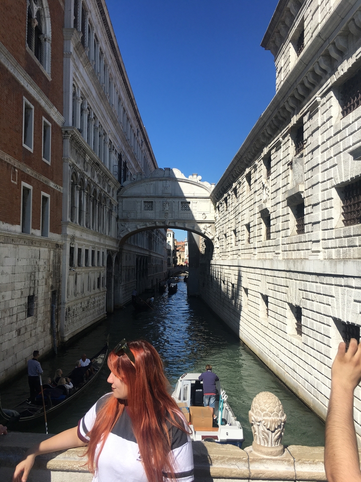 Canal pittoresque avec pont et bâtiments historiques.