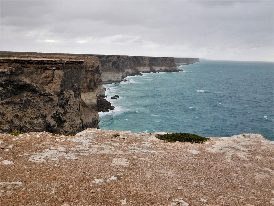 Falaises côtières avec vue sur l'océan sous un ciel nuageux.