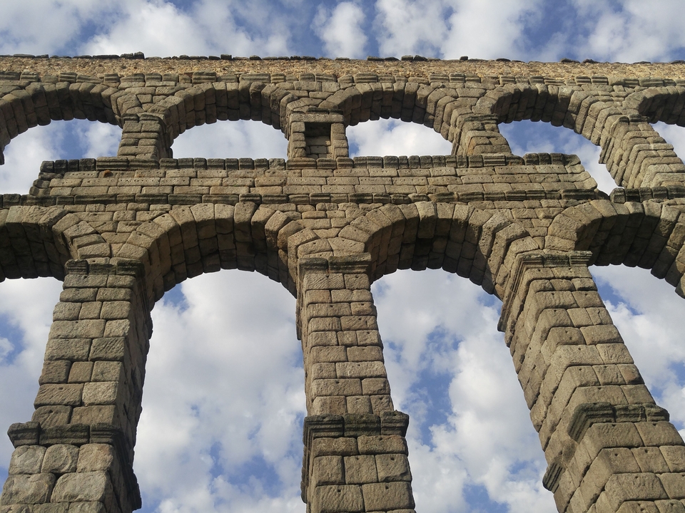 Aqueduc antique en pierre avec arches.
