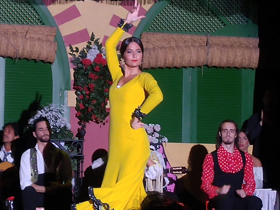 Une danseuse de flamenco dans une robe jaune pendant un spectacle.