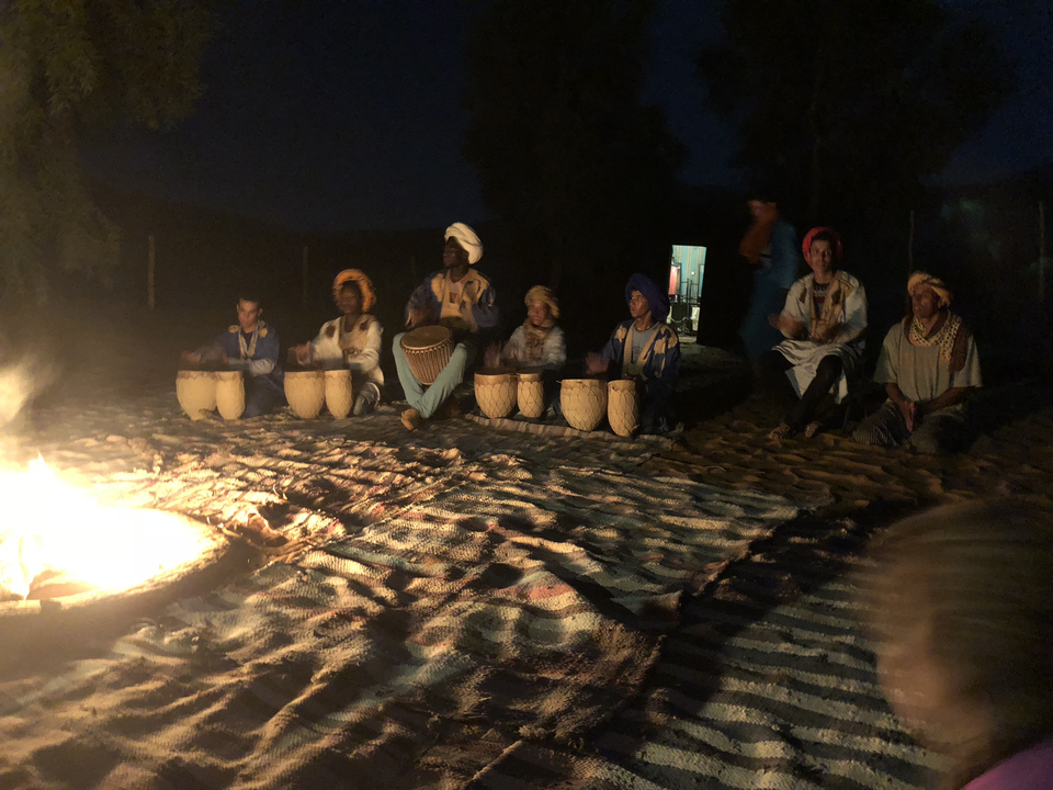 Menschen versammelten sich nachts um ein Lagerfeuer mit Trommeln.