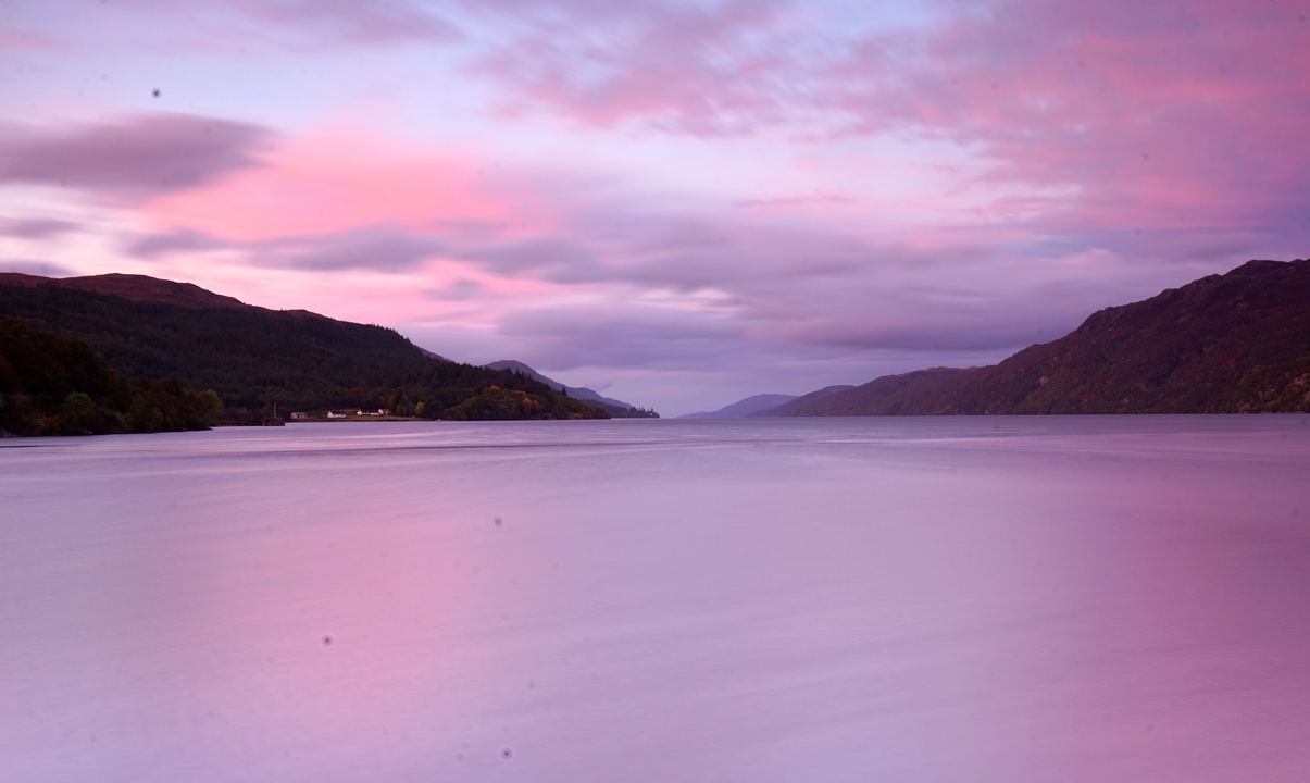 Belle scène de lac avec des reflets de coucher de soleil violet.