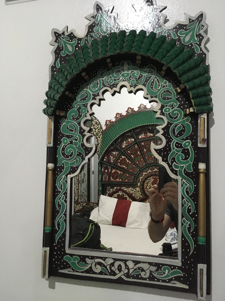 Cadre de miroir marocain complexe avec reflet visible.