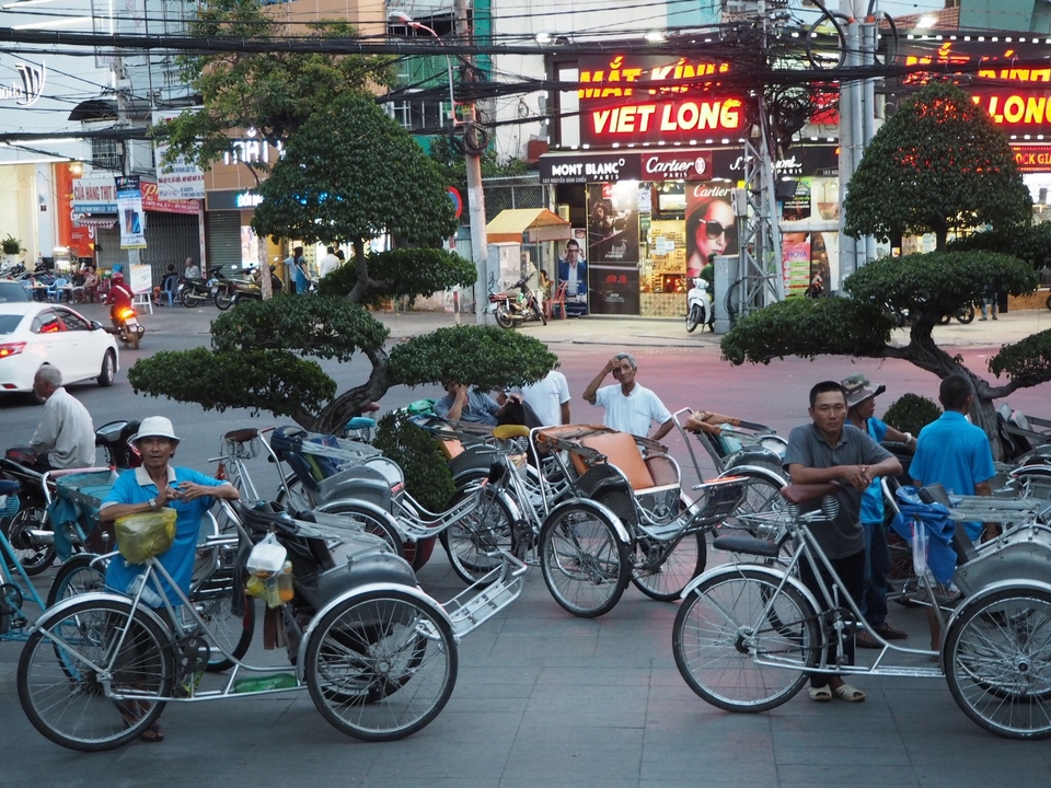 Groupe d'hommes avec des vélos dans un environnement urbain animé.