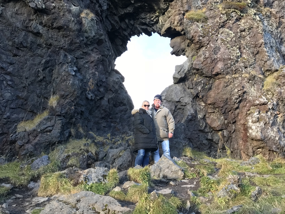 Deux personnes posant sous une arche rocheuse.