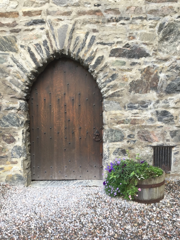Vue en gros plan d'une vieille porte en bois enchâssée dans un mur de pierre.