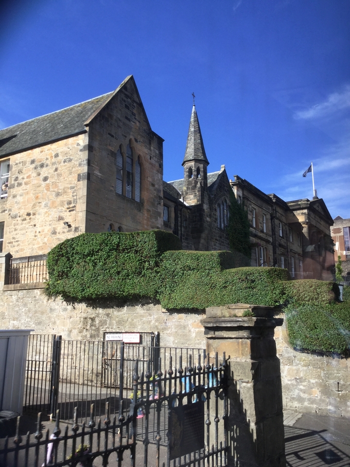 Un bâtiment historique en pierre avec des vignes qui poussent dessus.
