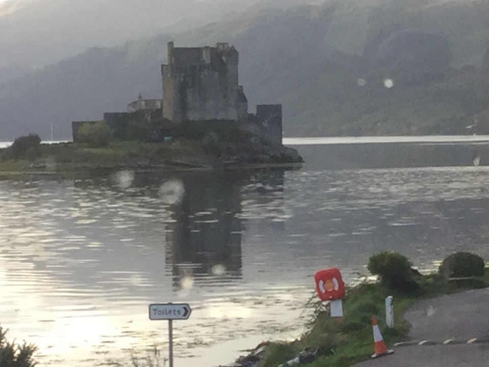 Un château se reflétant dans un lac par un jour de pluie.