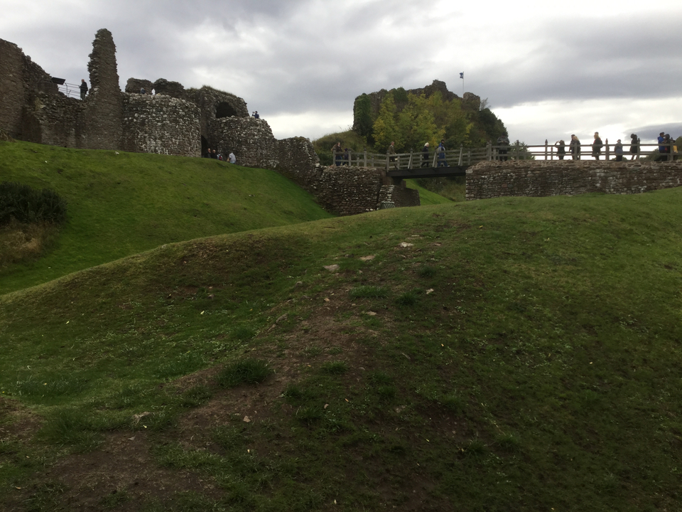 Des gens explorant des ruines anciennes avec de la verdure.