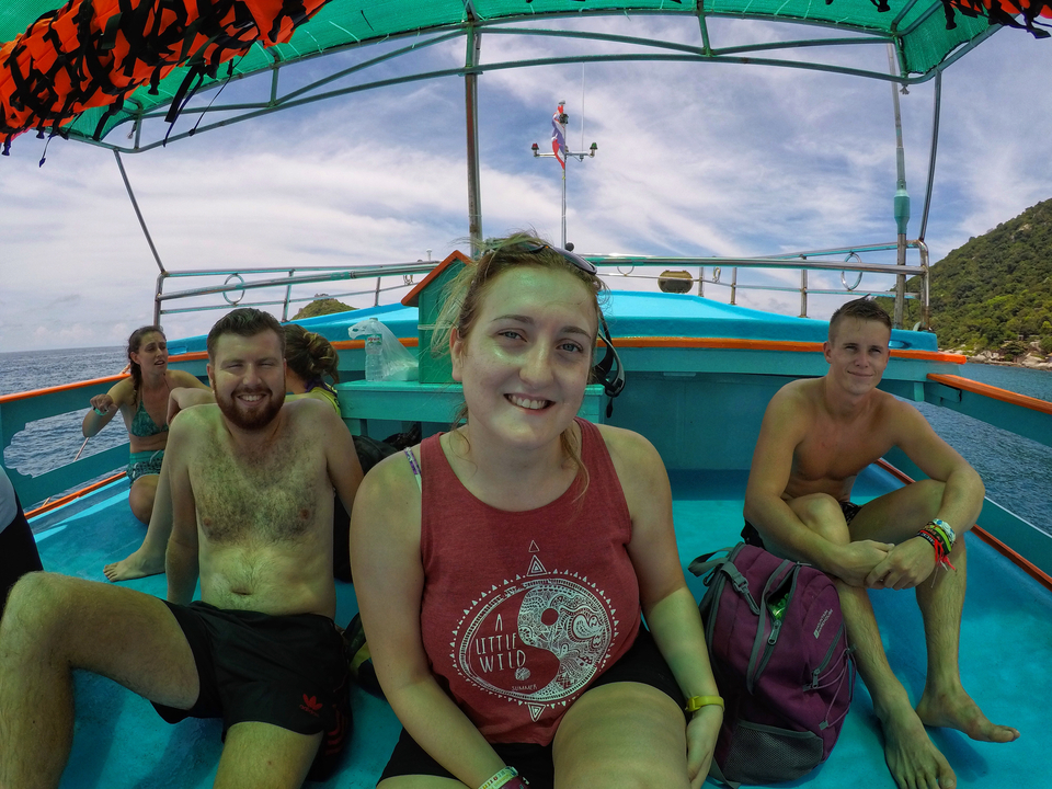 People enjoying a sunny ride on a boat with clear blue water surrounding them.