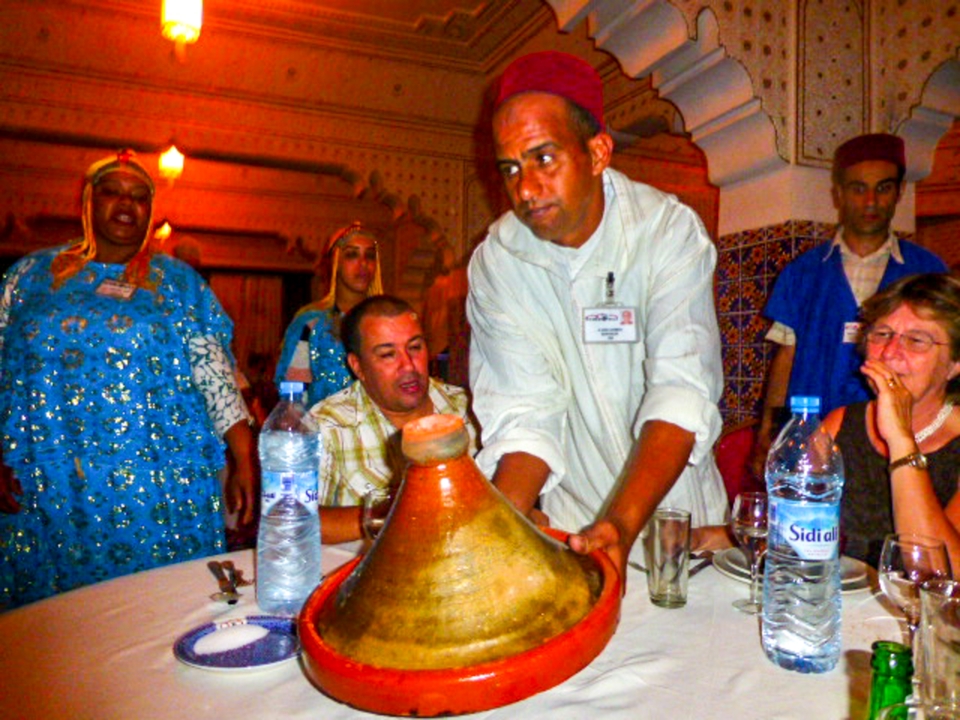 Groupe de personnes dînant à l'intérieur, tenue traditionnelle.