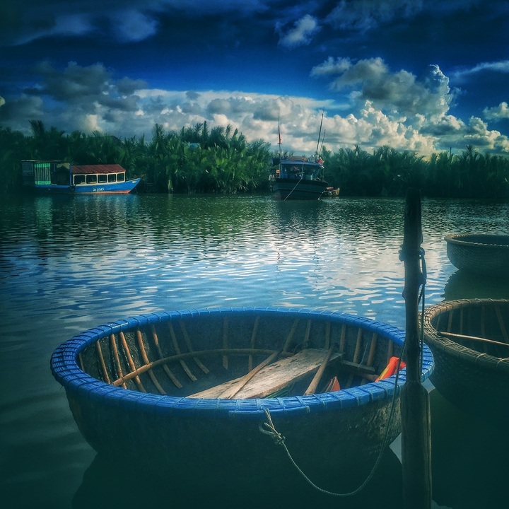 Bateaux-paniers ronds sur une rivière sous un ciel bleu.