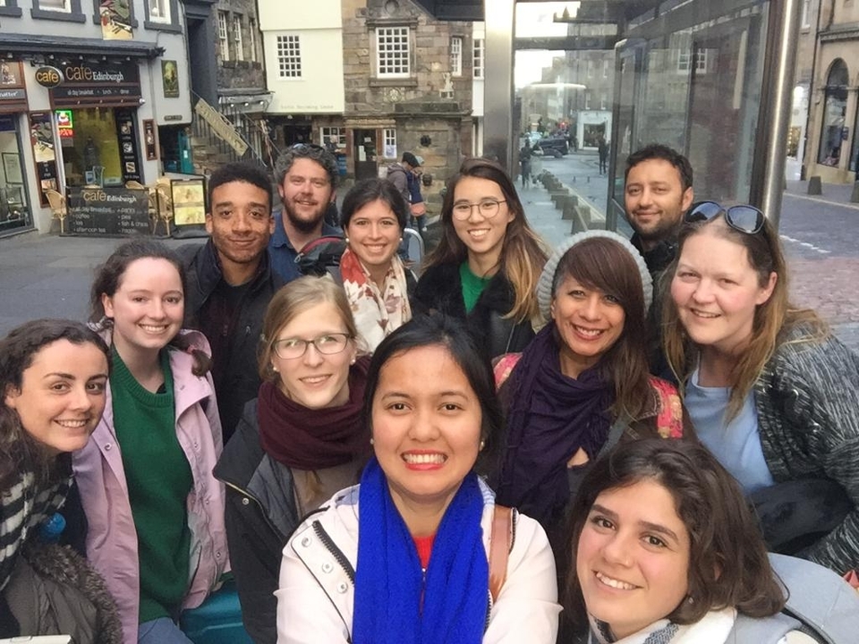 A group of people taking a selfie on a city street.