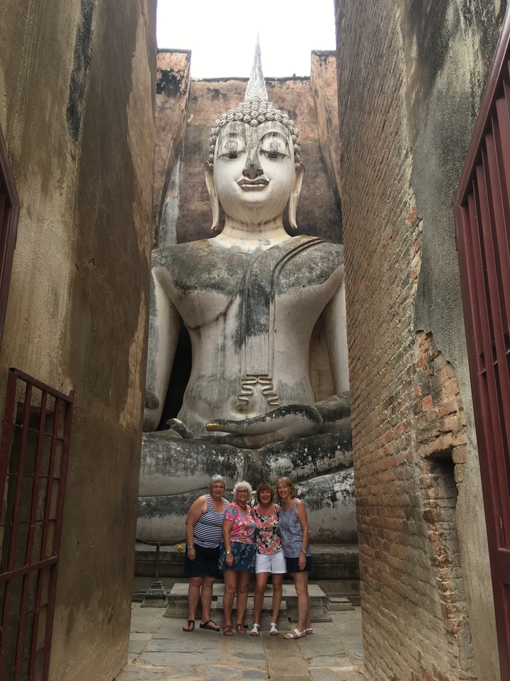 Grande statue de Bouddha assis parmi d'anciennes briques.