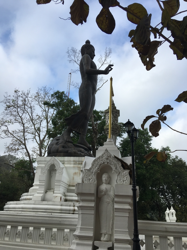 Statue d'une figure debout sur un socle élaboré.