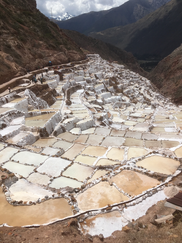 Mines de sel en terrasses avec des personnes qui marchent le long des sentiers.