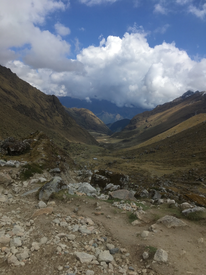 Vaste vallée au terrain accidenté sous un ciel couvert.