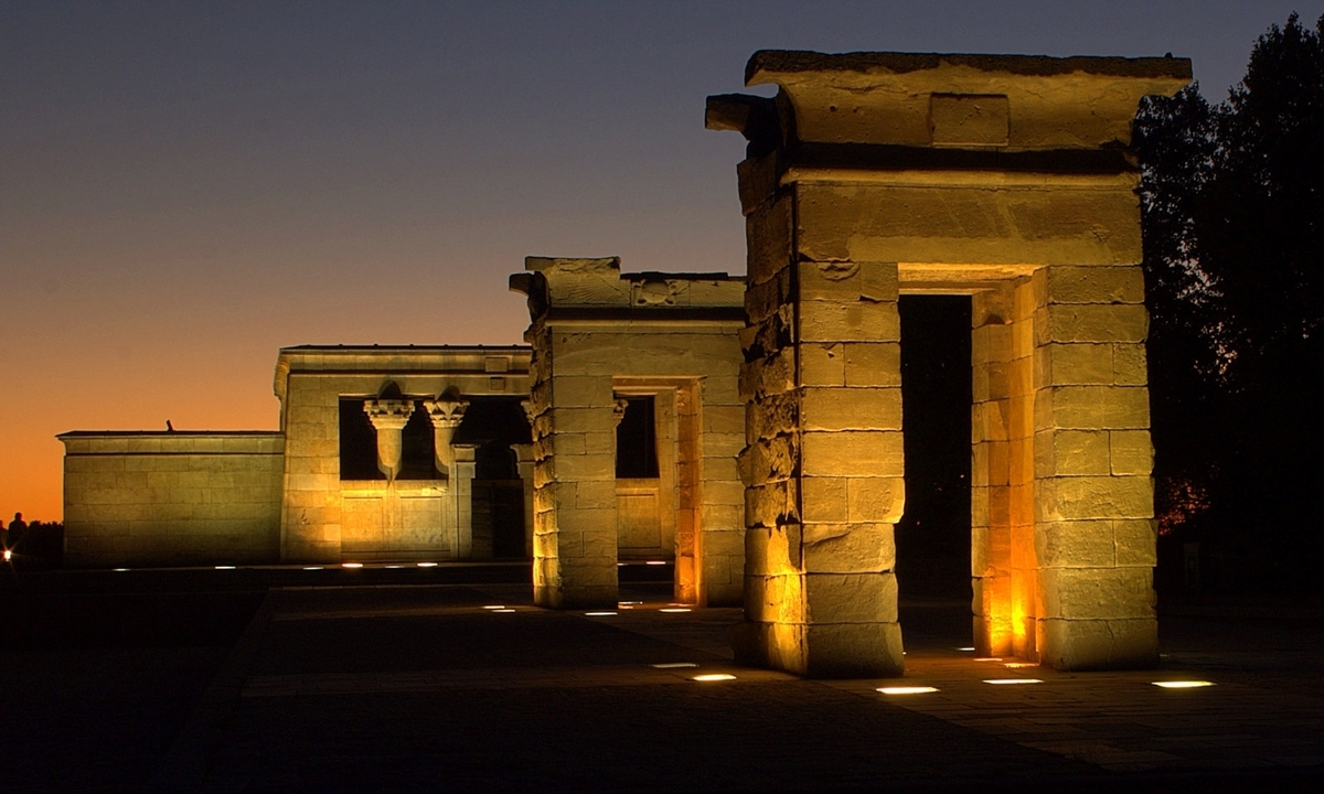 Structures de pierre antiques illuminées au coucher du soleil.