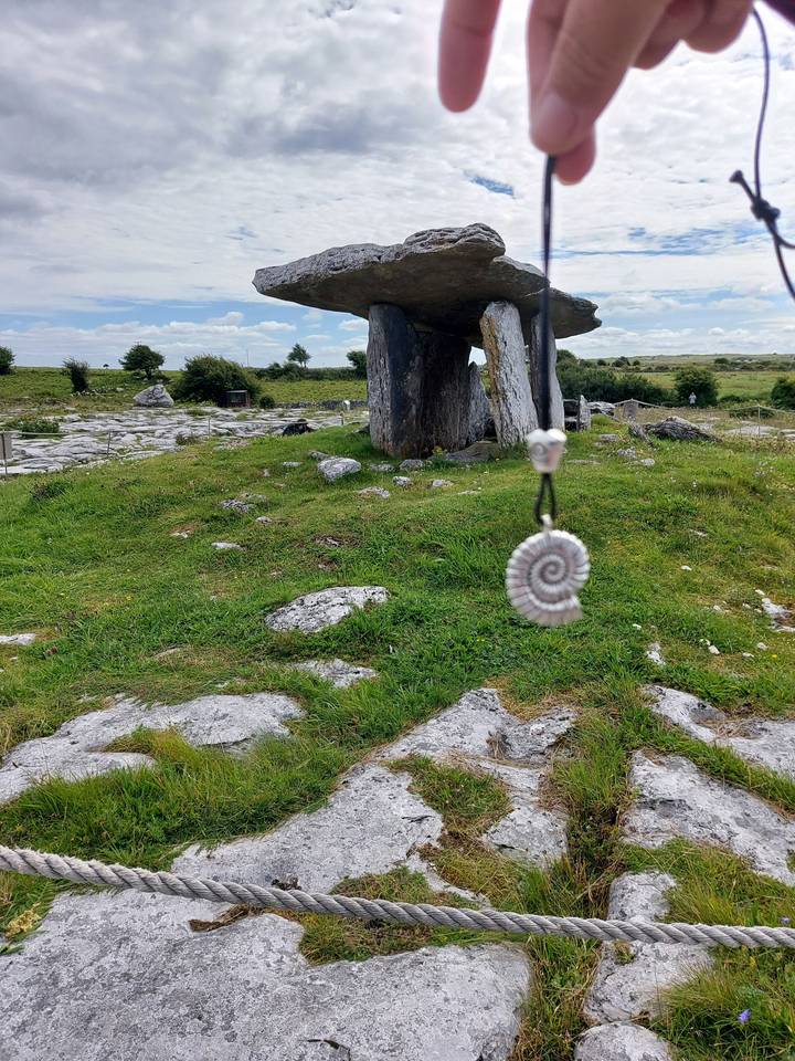 Dolmen de pierre ou tombe à portique avec un coquillage en spirale au premier plan.