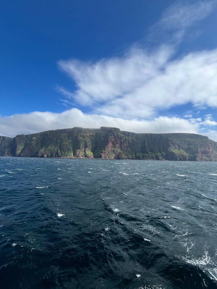 Falaises rencontrant la mer sous un ciel nuageux.