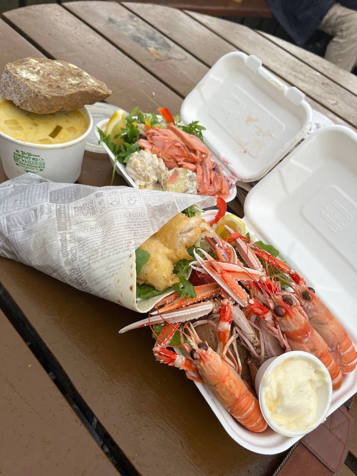 Plateau de fruits de mer avec crevettes et poissons dans des contenants.