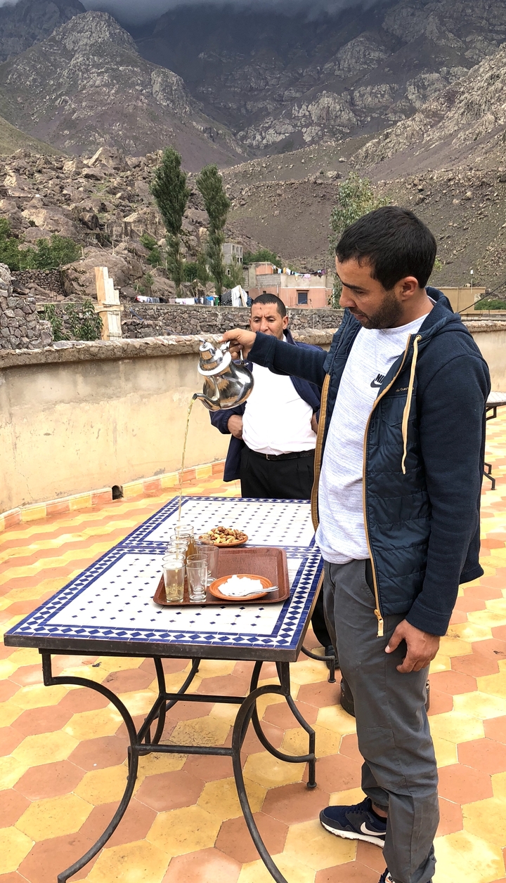 Une personne versant du thé dans un cadre marocain traditionnel.
