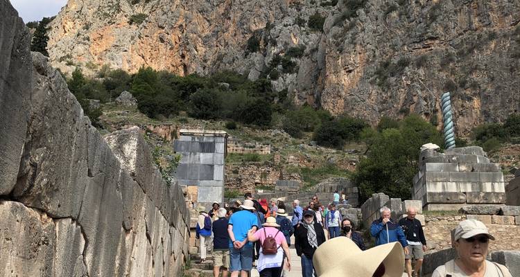 Tourists walking on ancient stone steps outside.