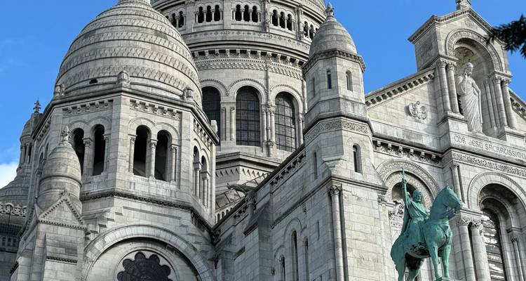 A detailed close-up of the Sacré-Cœur Basilica against a blue sky.