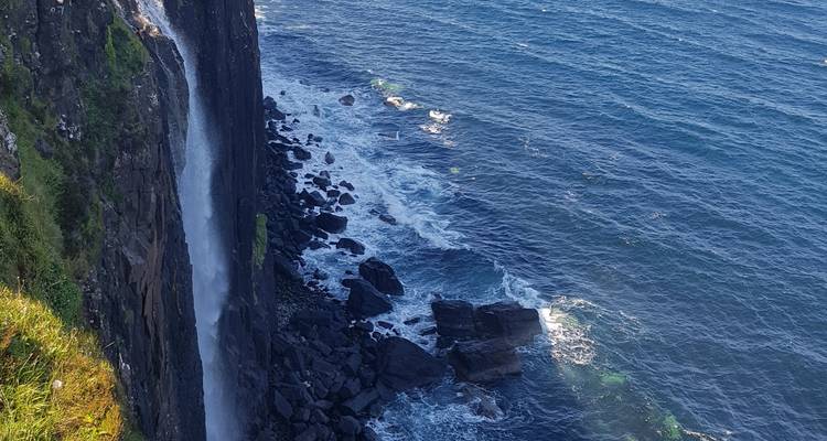 Cascada que desciende por un acantilado hasta el mar.