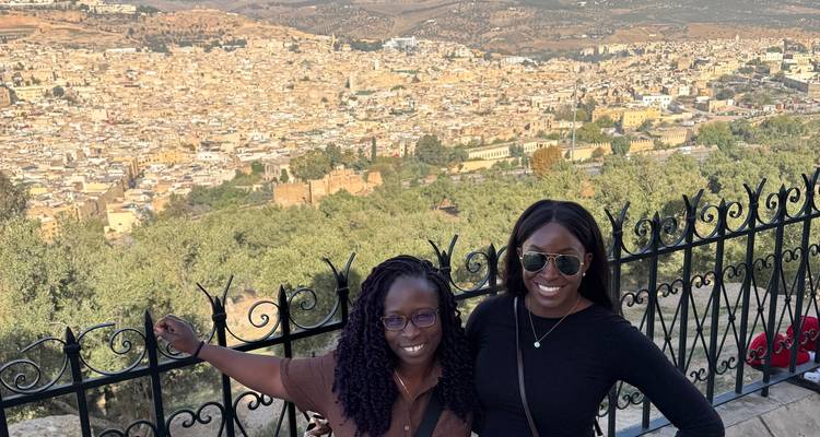Two women in front of a cityscape view.