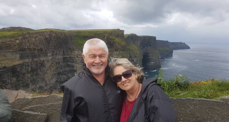 Pareja posando con una vista de los Acantilados de Moher.