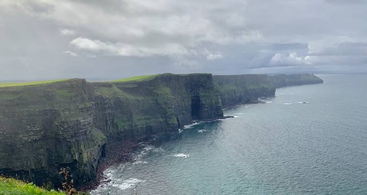 Cliffs of Moher overlooking the sea on a cloudy day.