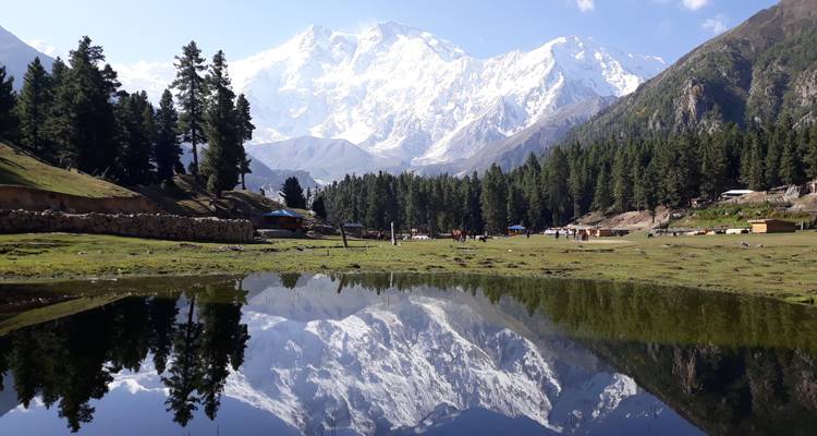 A serene landscape with a mountain reflection in a calm lake.