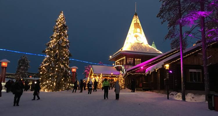 Feestelijk verlichte gebouwen en een grote kerstboom in het Kerstmandorp in Rovaniemi.